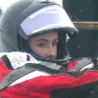 a young boy sits in a box with his snow gear on.
