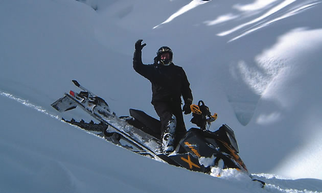 man on a sled waving