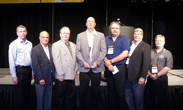 men standing on stage holding an award