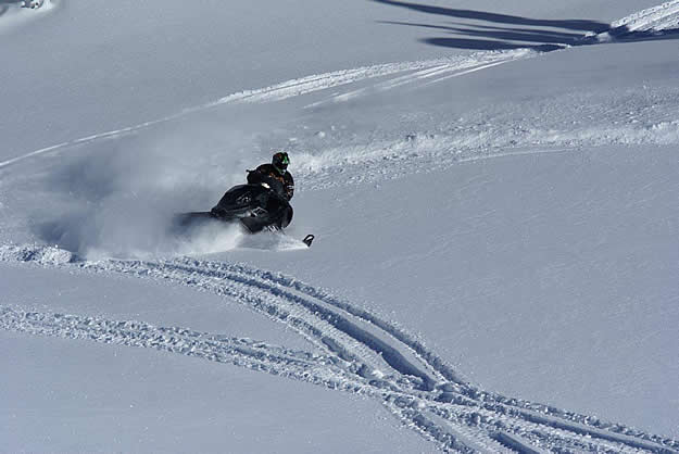 Photo of a snowmobiler carving up snow