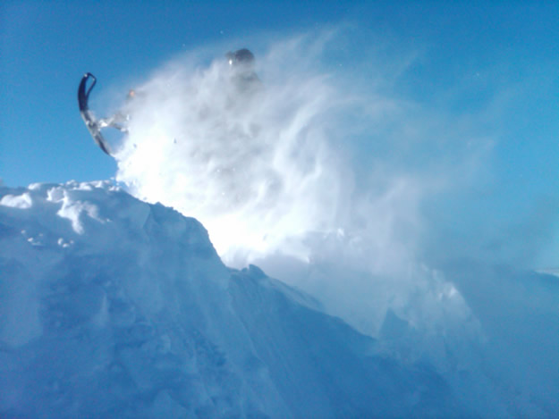 Someone taking a jump on a snowmobile