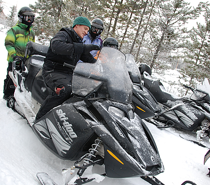 People getting ready to ride their snowmobiles
